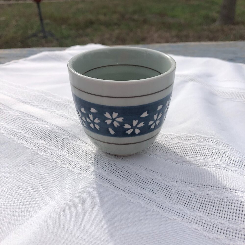 Japanese-style ceramic teacup with blue and white cherry blossom design